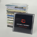 Stack of photo magnets with a 'Picture 2 Magnet' product in front on a light gray background