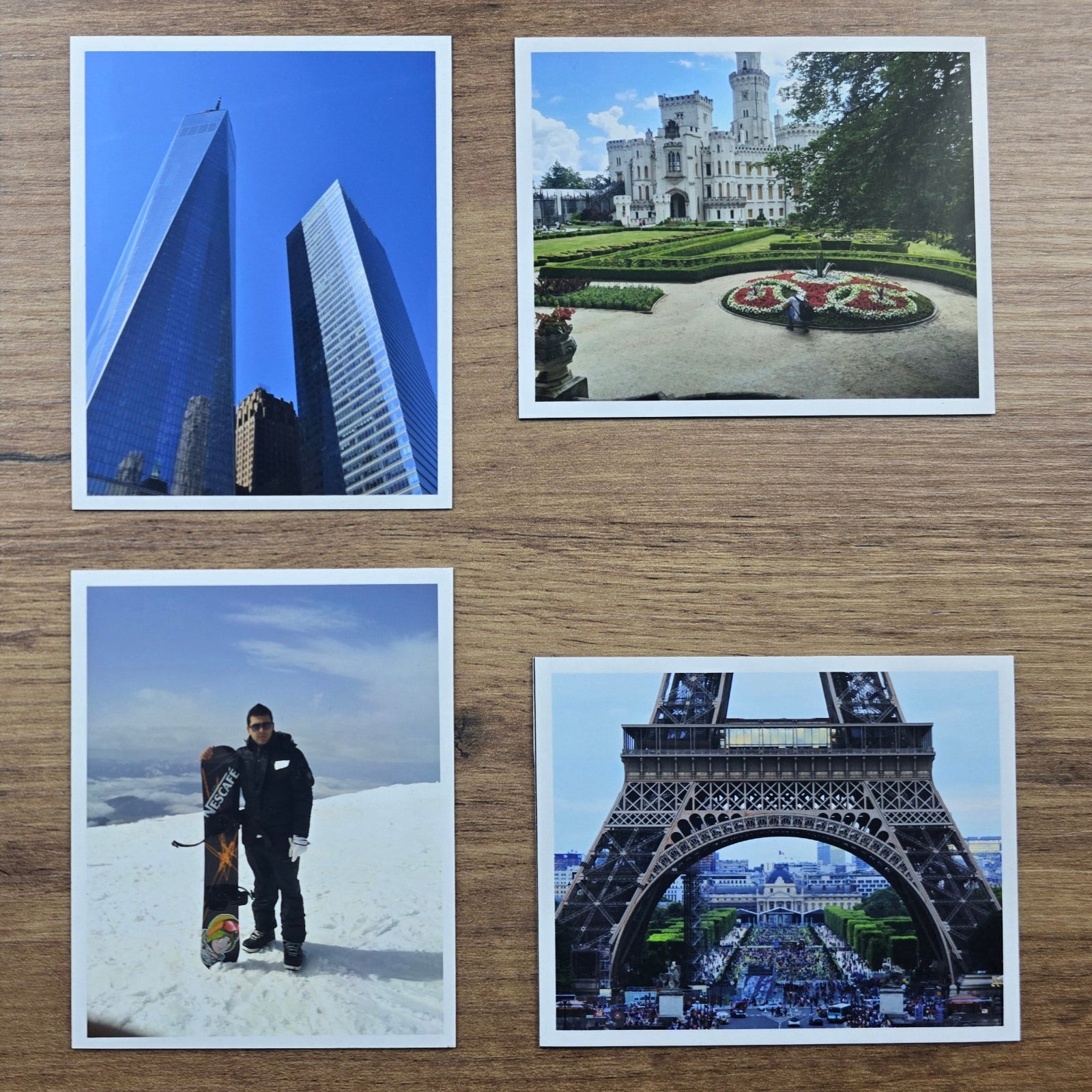 Collection of four magnet photos featuring various landscapes and landmarks on a wooden surface.