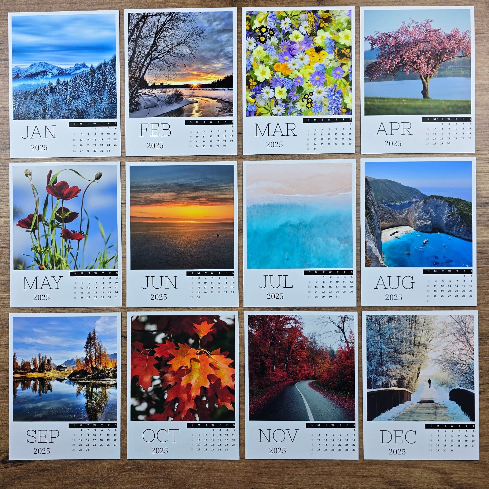 Photo magnet calendar with monthly landscape images on a wooden surface