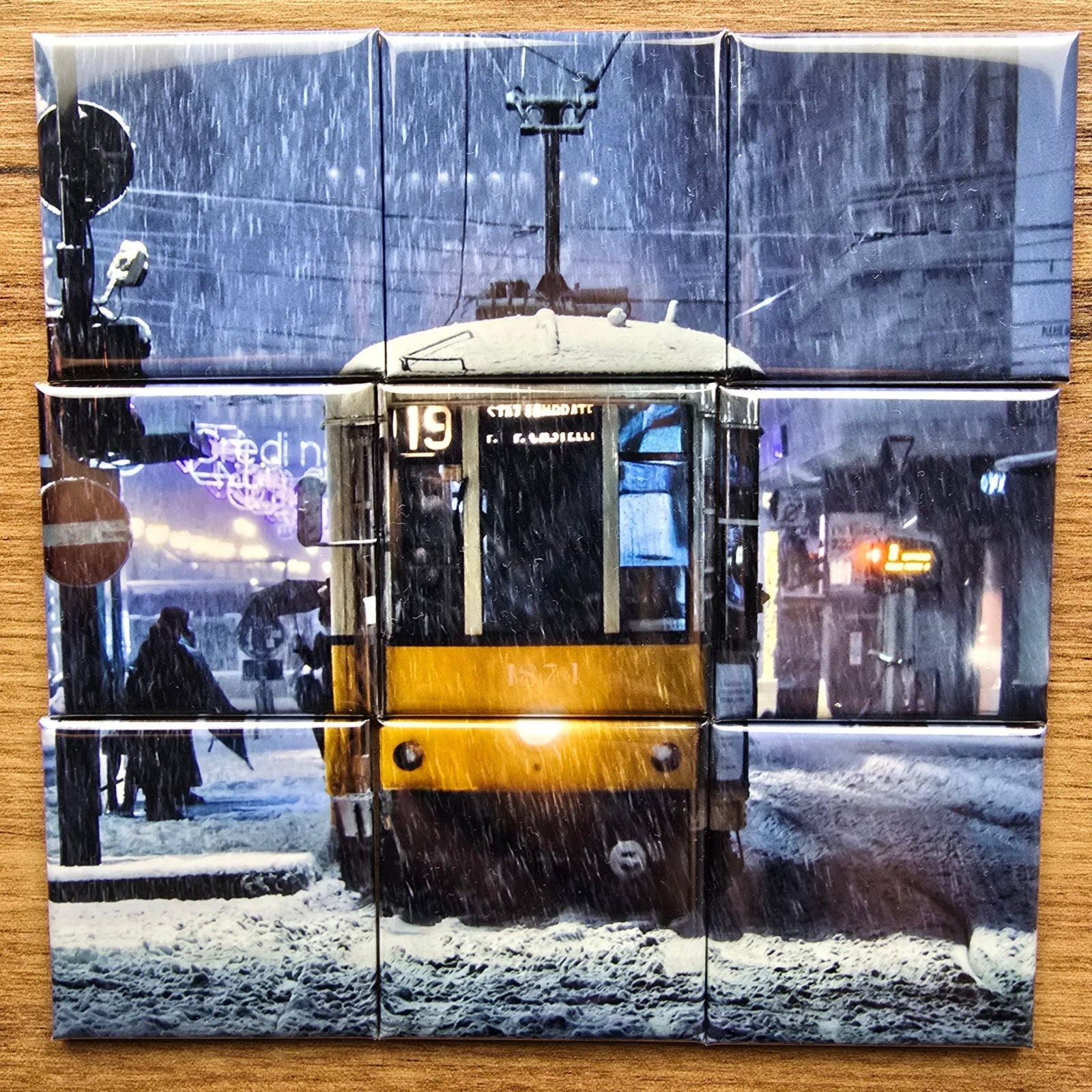 Nine-piece photo magnets artwork of a futuristic cityscape on a wooden surface