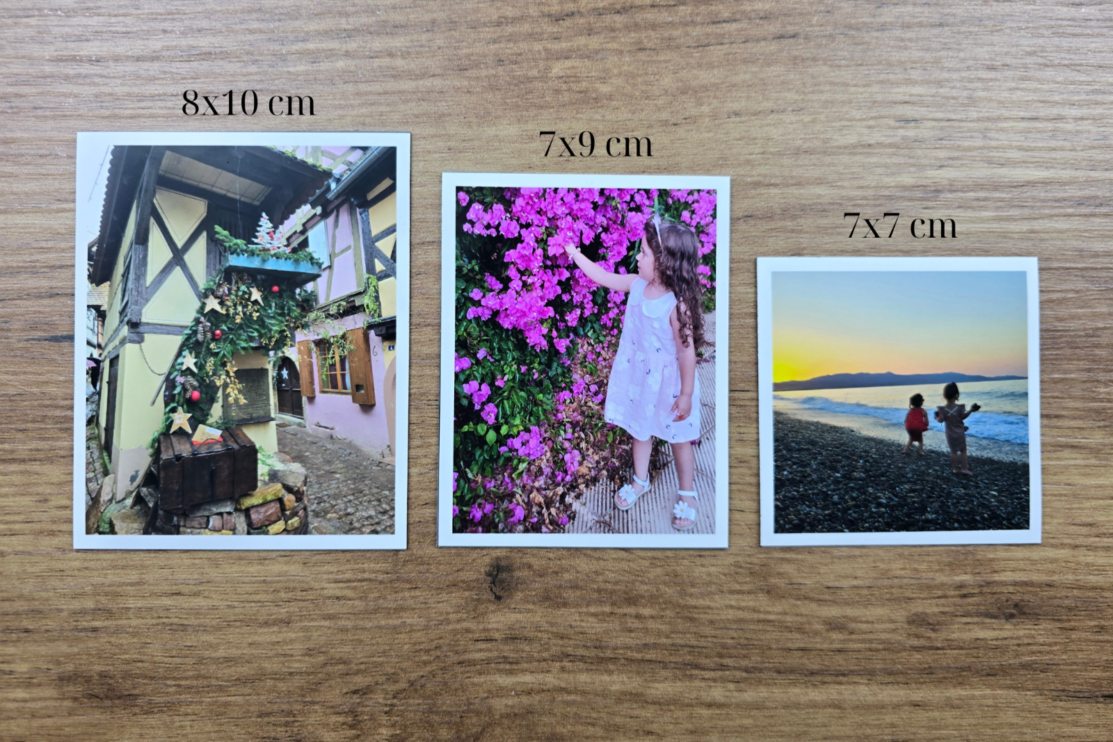 Three magnet photo prints of different sizes on a wooden surface